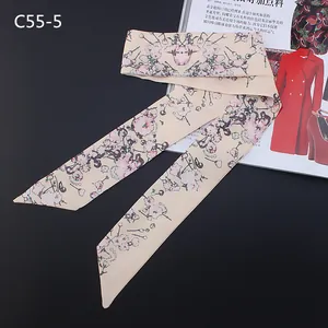 Close-up of narrow floral silk scarf with pink cherry blossoms on beige chiffon