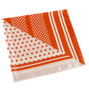 Detailed texture of square satin scarf with bright orange polka dots and stripes