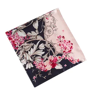 Détail du motif floral sur foulard en soie noir et rose avec texture satinée lisse