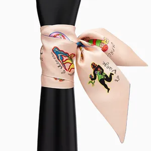 Elegant silk twilly scarf with tarot zodiac print tied in a bow on a black display arm