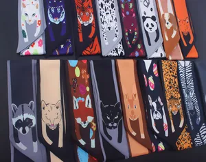 Détails de plusieurs foulards en soie aux imprimés animaliers et bordures contrastées