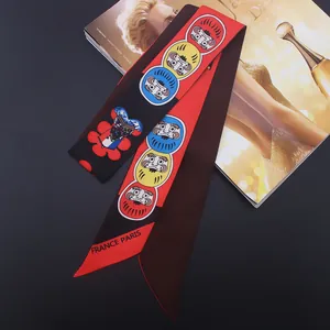 Elegant 120cm Twilly silk scarf with Daruma motifs on fashion magazines background