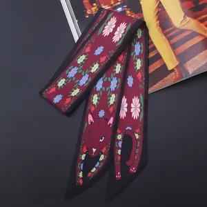 Détail de l'écharpe en soie bordeaux avec imprimé chat floral et texture satinée