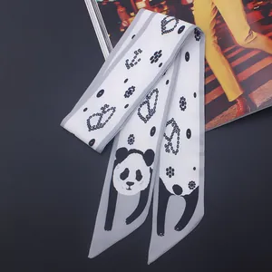 Gros plan du foulard en soie noir et blanc avec motifs de pandas mignons et de pois