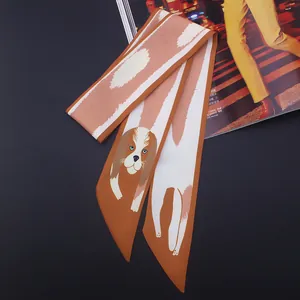 Détail d'un foulard en soie orange avec motif chien Cavalier King Charles Spaniel