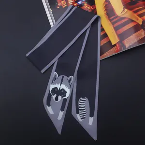 Détail d'un foulard twilly en soie avec motif de raton laveur sur fond gris foncé pour sac