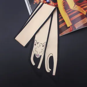 Détail d'un foulard Twilly en satin beige avec motif chat et bordure noire élégante