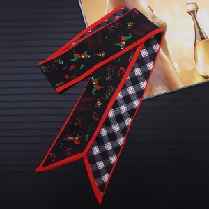 Detalle de pañuelo Twilly de seda de doble cara con motivos ecuestres y borde rojo fino