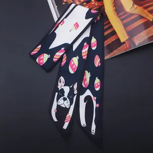 Détail d'un foulard en soie noir et blanc avec motifs de chiens et ornements festifs