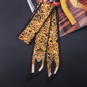 Détail d'un foulard en soie à imprimé léopard aux motifs animaliers orange et noir