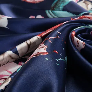 Macro view of silky satin scarf fabric with elegant floral print in navy and pink