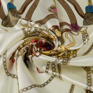 Detail of silk square scarf featuring gold chains and horse harness motifs