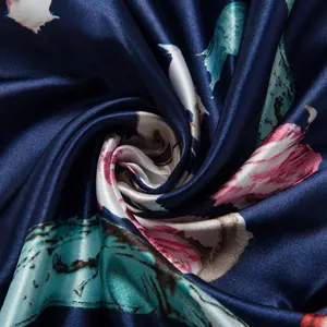 Macro shot of large floral patterns on smooth navy blue satin silk scarf fabric