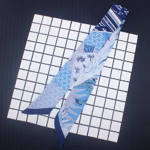 Dettaglio di un foulard in seta blu stampata con motivi di cavalli per manici di borse
