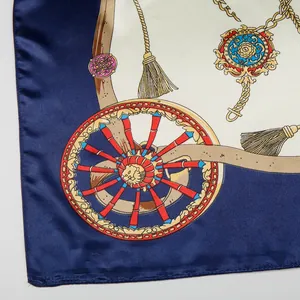 Detailed macro view of satin silk scarf with vintage wheel patterns and gold fringe motifs