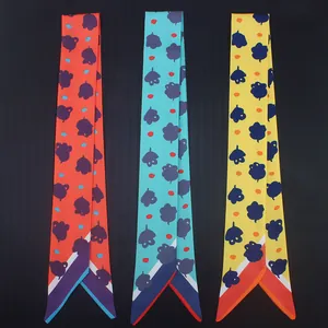 Detailed view of three vibrant printed twilly scarves with abstract floral patterns