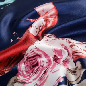 Macro shot of navy blue silk scarf featuring realistic pink rose patterns and satin texture
