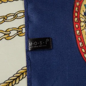Close-up of silk-textured scarf showing intricate gold chain patterns and stitched edge