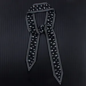 Detalle del pañuelo twilly de 120 cm con calaveras en blanco y negro para bolsos