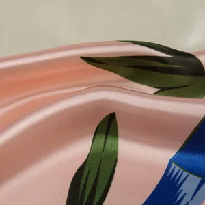 Detailopname van zijdeachtige satijnen stof met roze bloemenprint en bamboepatronen