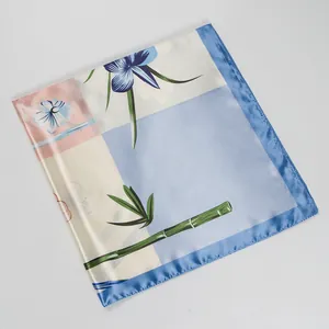Detail van zijdeachtige satijnen sjaal met bloemen, bamboe en blauwe zoomlijn
