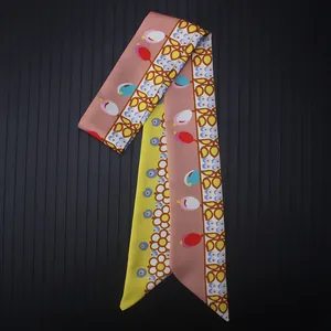 Detailed flat lay of a satin silk ribbon scarf with tulip floral prints on striped background