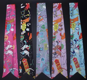 Detailansicht von fünf bunten Seidenschals mit grafischen Mustern für Handtaschen