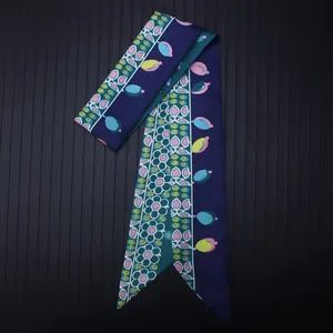 Detail of silk twilly scarf featuring colorful dots and floral patterns on navy blue