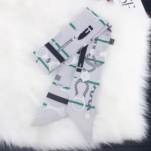 Detail of silk twilly scarf with equestrian horse bit print on white faux fur background
