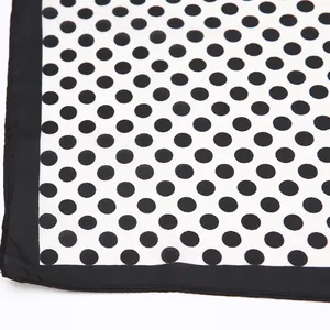 Détail du foulard chic en soie à pois avec des bords ourlés et une texture de haute qualité