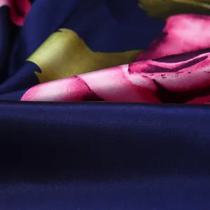 Close-up of silk scarf showing glossy satin texture and detailed pink floral patterns