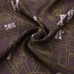 Macro detail of silk-like satin scarf featuring vintage map patterns and designer prints