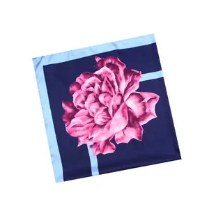 Detail of blue silk scarf featuring a large pink rose print on smooth satin fabric