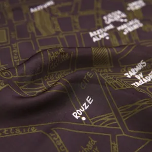 Macro view of silk satin scarf featuring vintage French city map print and elegant texture