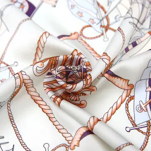 Detail van een zijden sjaal met nautische print, touw- en ankermotieven in spiraalvouw