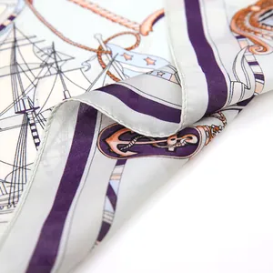 Detailopname van de zijden sjaal met nautische zeilbootmotieven en ankers in blauw