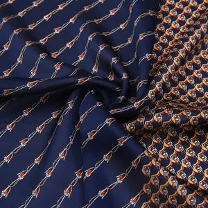 Detailed macro shot of navy blue silk scarf with elegant chain print and satin finish