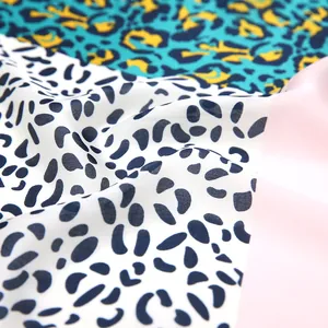 Detailed view of leopard print satin scarf featuring mint green, navy, and pink silk texture