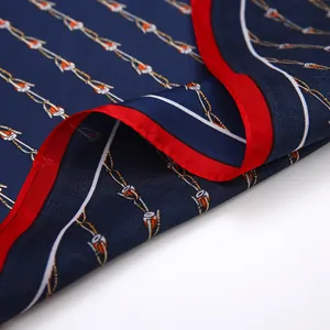 Detail of navy blue silk-like square scarf with red borders and chain pattern texture