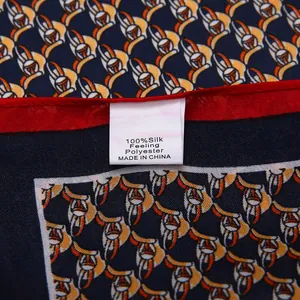 Detail of red stitched hem and fabric label on a blue geometric pattern silk feeling scarf