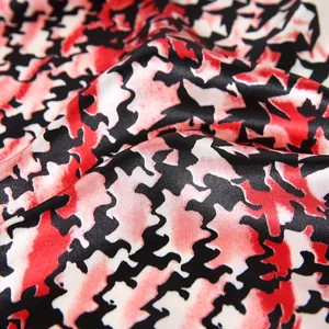 Κοντινό πλάνο κόκκινου και μαύρου μοτίβου houndstooth σε μεταξένιο σατέν ύφασμα