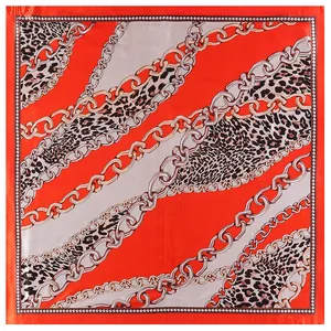 Square silk scarf with leopard print and golden chain pattern in vibrant orange red