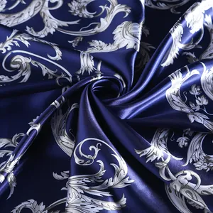 Detailed macro shot of silky navy blue fabric with vintage baroque floral patterns