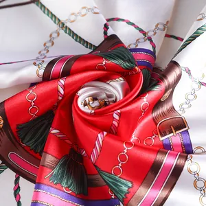 Close-up of silk scarf folded into a rose shape featuring chain and tassel patterns