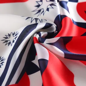 Close-up of silk-textured square scarf featuring red and blue nautical pattern folds
