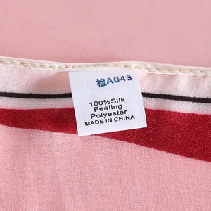 Detail of pink and red geometric silk-feel polyester scarf with 100% silk feeling label
