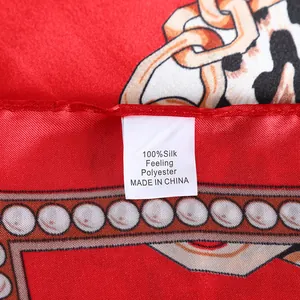 Macro view of red silk-feeling polyester scarf with gold chain and leopard print