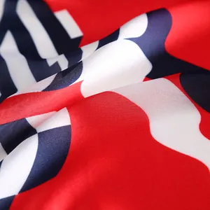 Close-up of red and blue geometric patterns on glossy 53cm silk-like square scarf