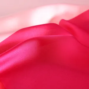 Detailed macro view of the silky satin texture and pink gradient colors of the scarf