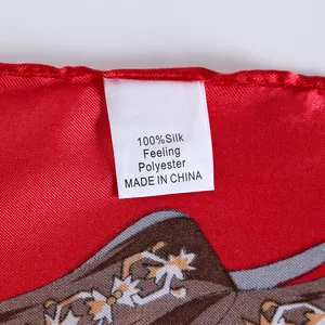 Detailed view of red silk-feel scarf label showing fabric quality and fine edge stitching